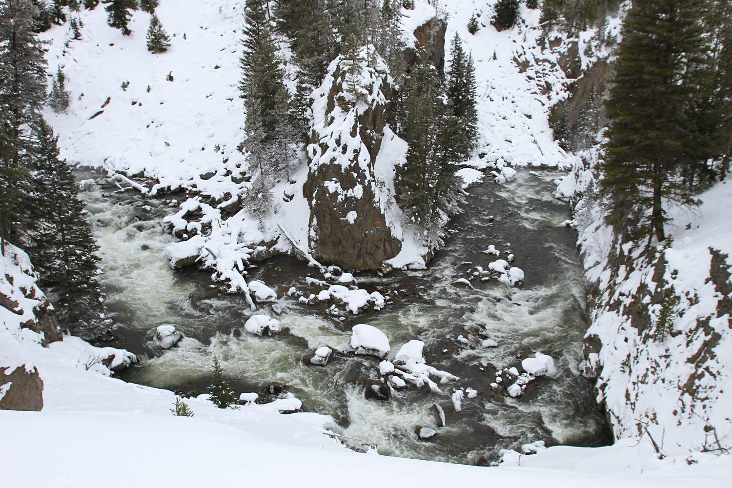 The Firehole River running fast between the dark walls of Firehole Canyon.